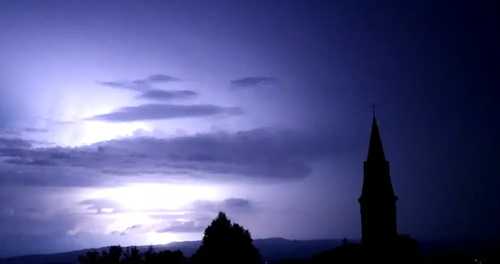 Le vue sur le village, de nuit, éclairée par un éclair. Une frame d'une vidéo qui a filmé un éclair, même.